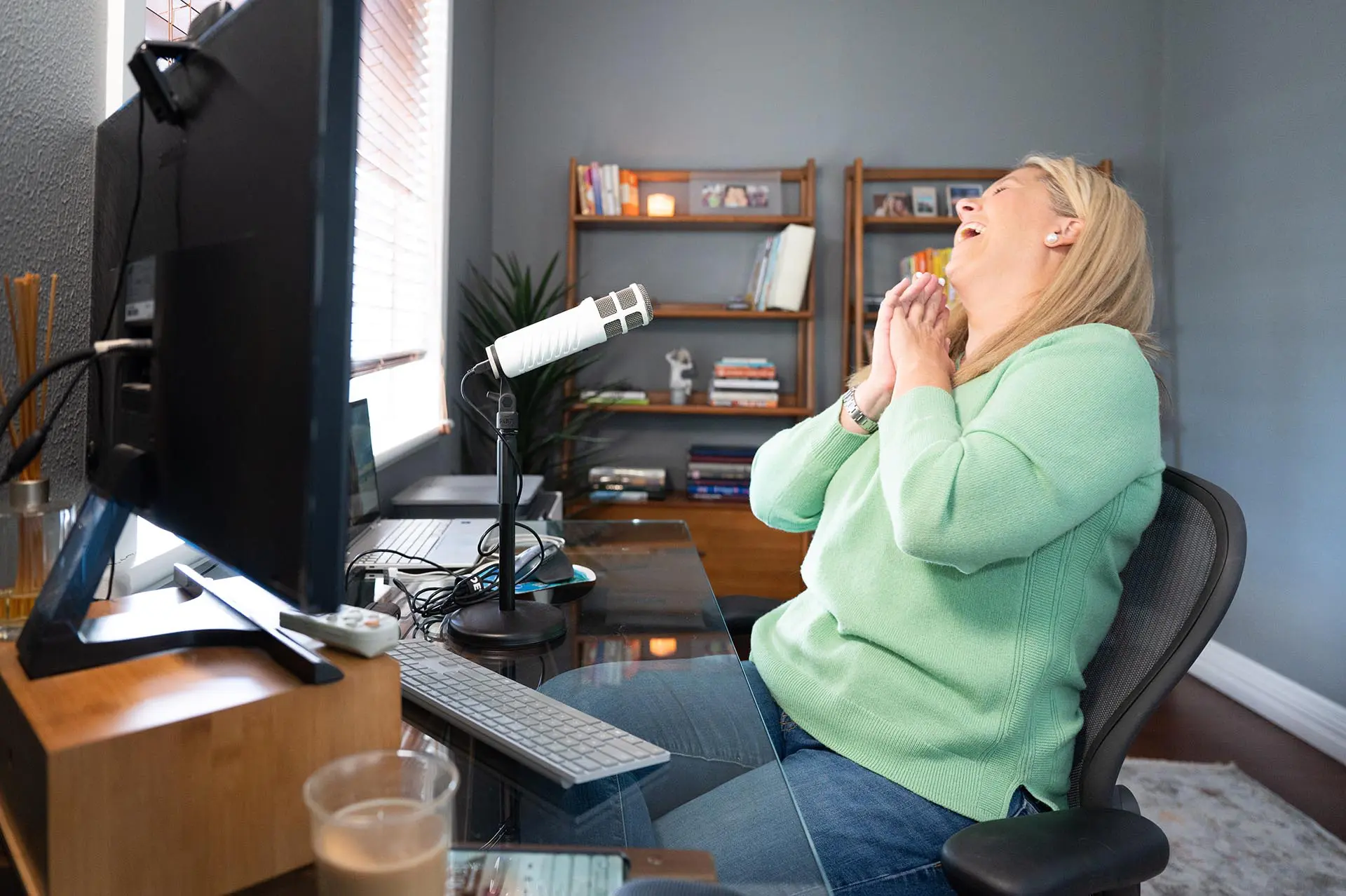 Meg laughing at her desk in the studio